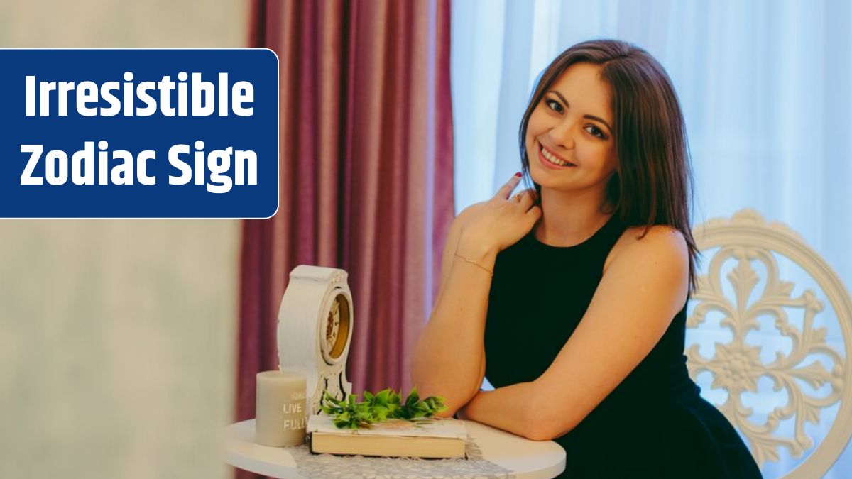 Girl smiles sitting on a chair, dressed in black, at a small round table.