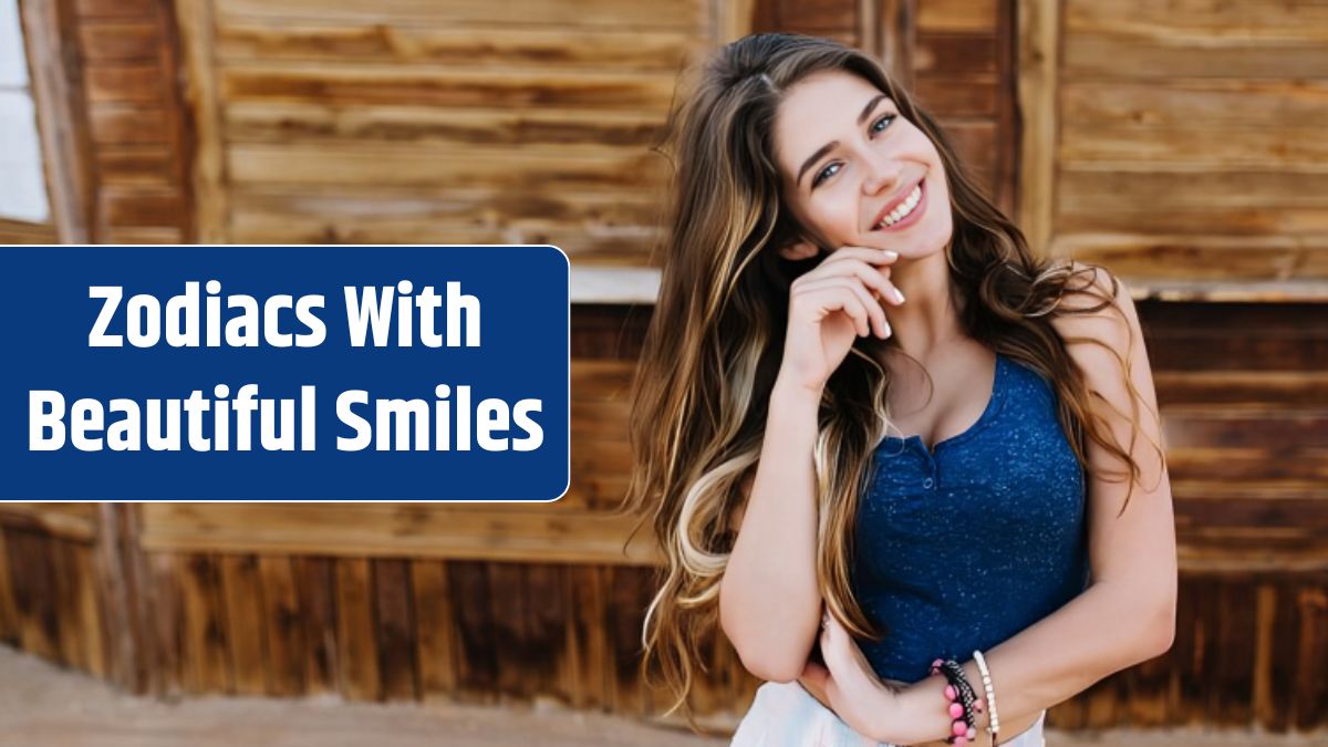 Elegant long-haired girl in cute bracelets playfully smiling, while posing in front of timbered building.